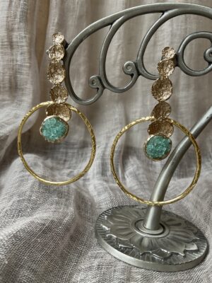 Goudkleurige oorbellen met groen blauwe kristallen van het Griekse juwelenmerk Taim