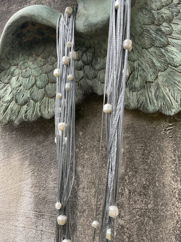 Grote maten mode Gent dames kledij. Creatieve Griekse juwelen. Lange halsketting met magnetische sluiting. Lange grijze touwen met grote witte glanzende parels van het Griekse juwelenmerk Taim.