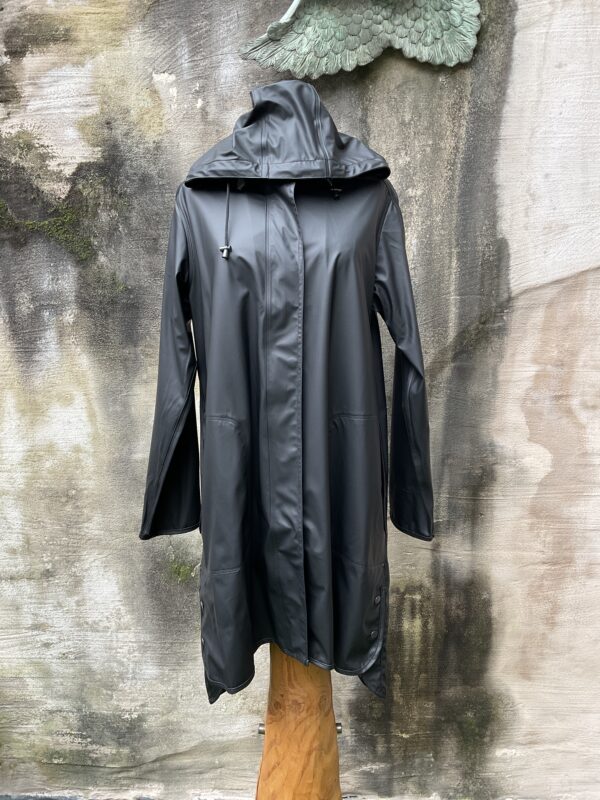 Grote maten mode Gent dames kledij en accessoires vrouwen. Halflange zwarte waterdichte regenjas van Ilse Jacobsen