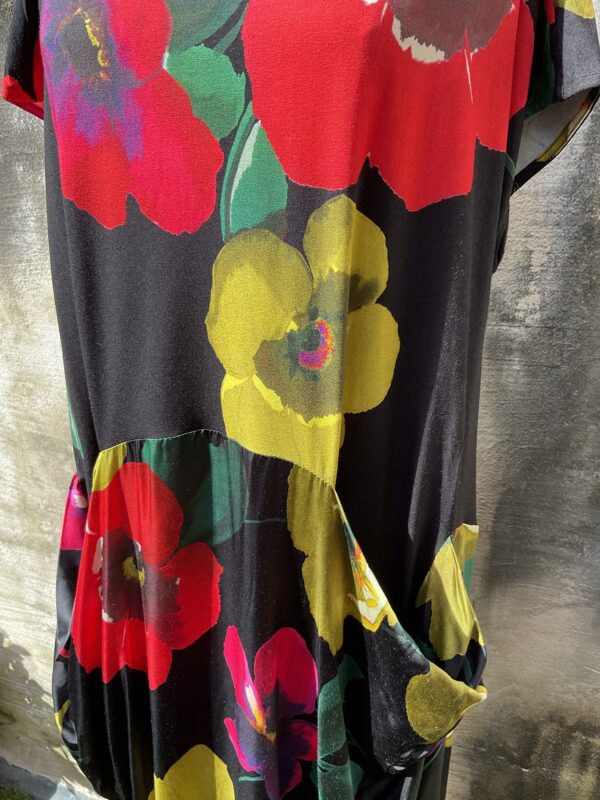 Grote maten mode Gent dames kledij en accessoires vrouwen. Halflange jurk met bloemenprint in diverse kleuren als rood, groen, geel, roze op zwart van Alembika