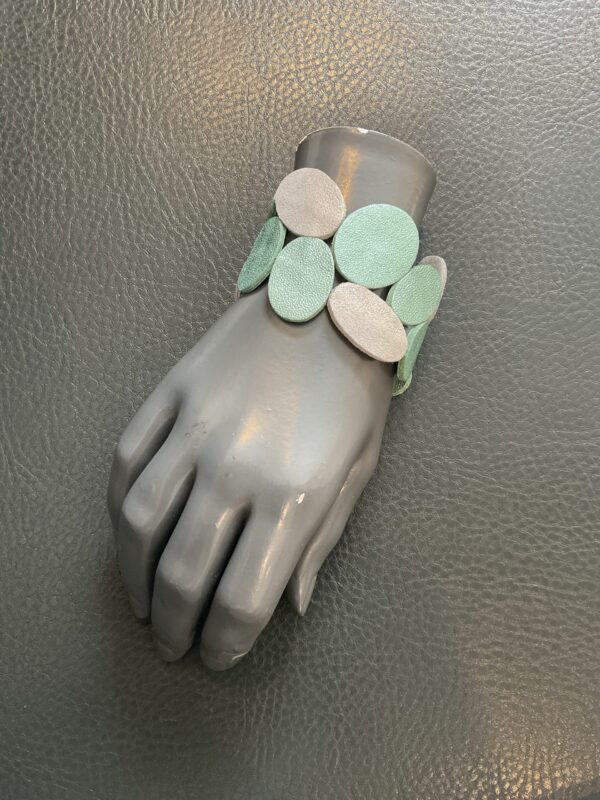 Kleurrijke, creatieve, artistieke en aparte armbanden en juwelen van het Griekse juwelenmerk Taim. Grote maten mode Gent dames kledij en accessoires vrouwen. Unieke en creatieve juwelen armband in zilver en munt groen metallic leder van het Griekse juwelenmerk Taim