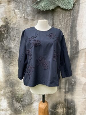 Kleurrijke, creatieve en aparte mode voor dames in Gent. Grote maten mode dames kledij en accessoires voor vrouwen met een maatje meer of minder. Zomerse blouse in 100% katoen in kleur zwart met zwart gekleurde versieringen van het Deense merk Masai