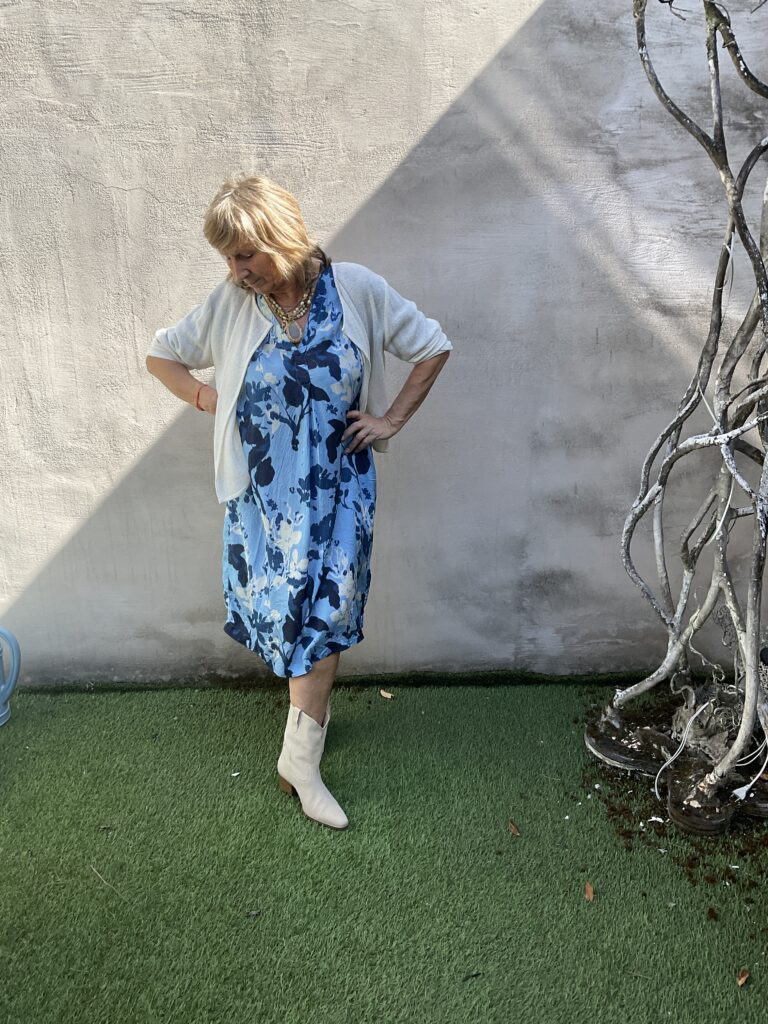 Kleurrijke, creatieve en unieke mode voor dames in hartje Gent. Halflange jurk in viscose met florale print in licht- en donkerblauw en wit van Masai. Korte jasje zonder sluiting in ecru van Masai