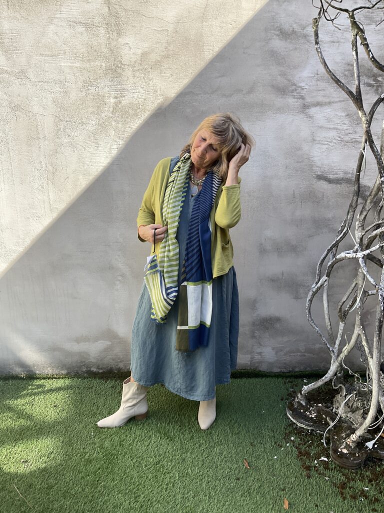 Kleurrijke, creatieve en aparte mode voor dames in hartje Gent. Grote maten mode dames kledij en accessoires voor vrouwen met een maatje meer of minder. Lange jurk met V-hals en korte mouwen in grijs blauwe kleur van Ishiko. Cardigan in grasgroene kleur in katoen van Mansted.
