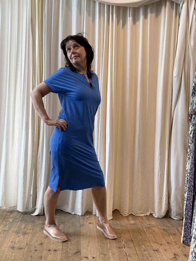 Kleurrijke, creatieve en unieke mode voor dames in Gent. Grote maten mode dames kledij en accessoires voor vrouwen met een maatje meer of minder. Hemelsblauwe jurk op knielengte met korte mouw en V-hals en kreukvrije travel stof.