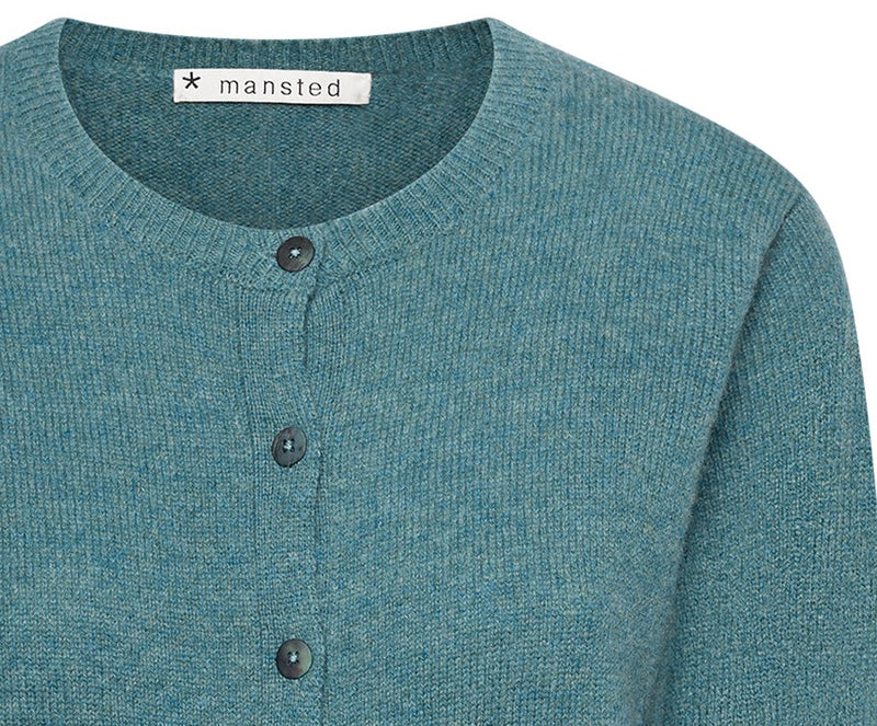 Kleurrijke, creatieve en unieke mode voor vrouwen in Gent. Grote maten mode dames kledij en accessoires voor vrouwen met een maatje meer of minder. Cardigan Midori met ronde hals en knoopjes in kleur emerald van Mansted. De Cardigan is gemaakt uit 100% wol.